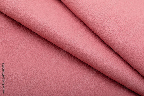Pink folded natural cow leather on the wooden table 