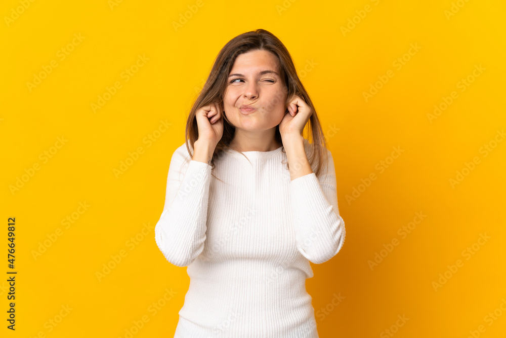 Young Slovak woman isolated on yellow background frustrated and covering ears Young Slovak woman isolated on yellow background frustrated and covering ears