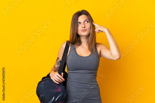 Slovak sport woman with sport bag isolated on yellow background having doubts and thinking