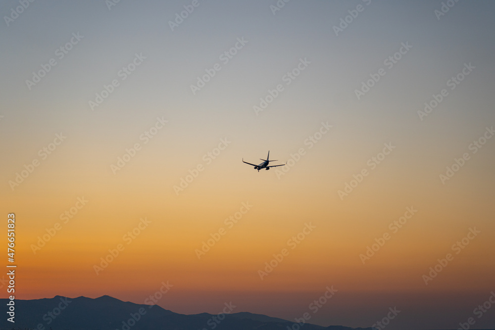 Verkehrsflugzeug landet während eines Sonnenuntergangs / Jet Aircraft landing during sunset with beauftiful orange sky 