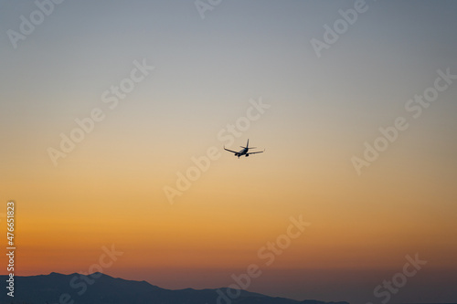 Verkehrsflugzeug landet während eines Sonnenuntergangs / Jet Aircraft landing during sunset with beauftiful orange sky 