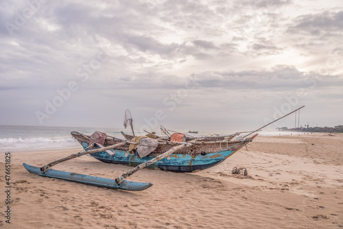 Wooden fishing boat on the beach of the atlantic ocean at the cloudy day.