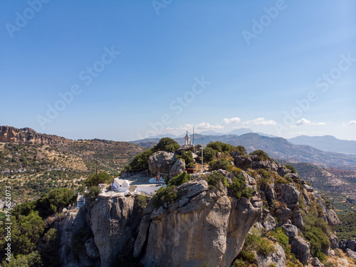 Timios Stavros Kirche auf Kreta, Griechenland, gebaut auf dem Gipfel eines kleinen Berges mit Gipfelkreuz und der Griechland Flagge photo
