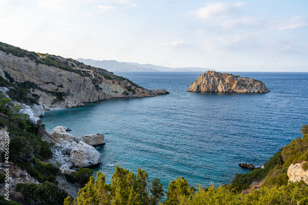 Blick auf eine felsige Steilküste mit dem türkis blauen Meer und einer kleinen Insel an der Mittelmeerküste auf Kreta in Griechenland
