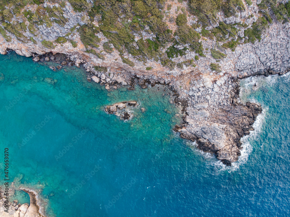 Eine Bucht mit türkisblauem Wasser an der der Mittelmeerküste auf Kreta in Griechenland, Drohnenfotografie / Luftaufnahme