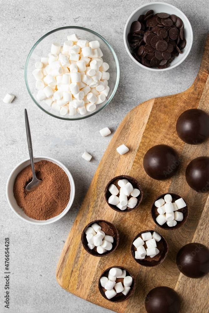 Ingredients for hot cocoa chocolate ball bomb with marshmallow and cooking process. Holiday winter drink. Handmade Christmas present. Ingredients for hot cocoa chocolate ball bomb with marshmallow and cooking process. Holiday winter drink. Handmade Christmas present.