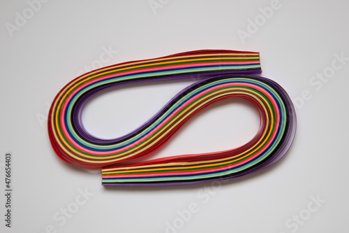Rainbow colored quilling paper laid out in waves and shapes. Colourful Paper. A set of multi-colored paper stripes for creativity.