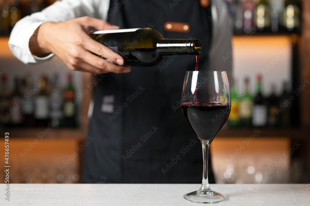 Unrecognizable Bartender serving red wine. High quality photo Unrecognizable Bartender serving red wine. High quality photo