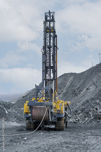 Large drill rig in an ore quarry. Preparation of boreholes for laying explosives in the quarry. Open-pit mining technologies.