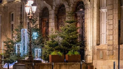 Magnificent Christmas decoration in front of the town hall, at night, fir trees and light garlands. © Natura