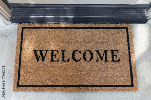 Clean welcome mat outside suburban front door.