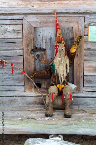 Doll in Meteņi mumming mask and costume, with colorful mittens and hat, and wearing felt boots. Meteni is ancient Latvian spring waiting holiday, when mummers scare the winter.