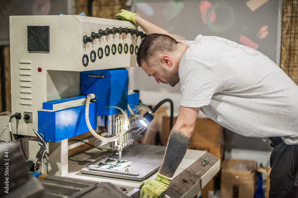 Worker technician operating with soft PVC dispensing machine in factory Worker technician operating with soft PVC dispensing machine in factory