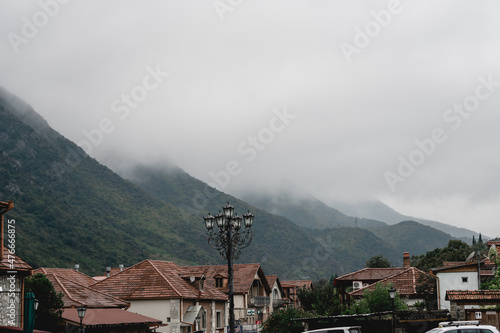 Fog over high mountains in the early morning. village houses mountain forest summer foggy landscape.