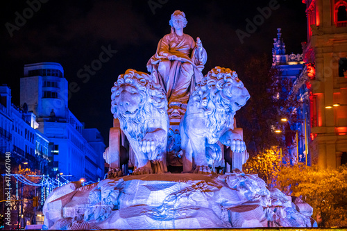 Statue of the goddess Cibeles with the two lions and Christmas lighting during a dark winter night in the emblematic Plaza de Cibeles in the city of Madrid, Spain photo