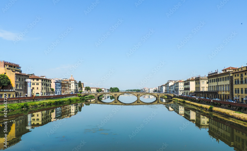 View of Ponte Santa Trinita (Santa Trinita Bridge) and it`s reflection in the waters of Arno River- Florence, Italy