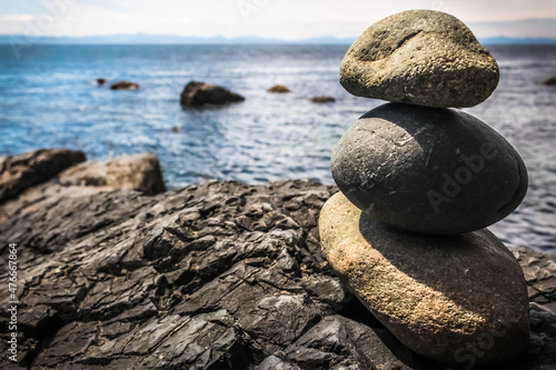 Photography A stack of rocks in front of the ocean