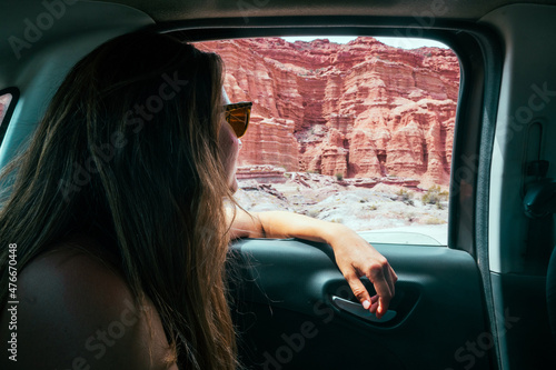 Young caucasian woman looking throw the windows in a car. Talampaya national park. photo