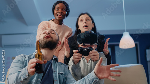 Woman with vr glasses and controller losing at video games to do fun activity after work. Colleagues cheering while playing game with tv console and virtual reality goggles after hours