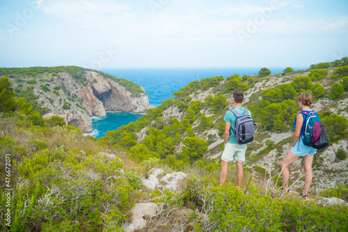 Couple Backpackers On Top Of Viewing Point Enjoying Scenic Views In Costa Brava, Spain.