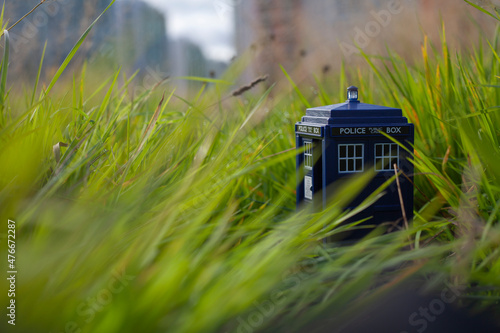 Fotografia Blue Tardis toy in green grass closeup