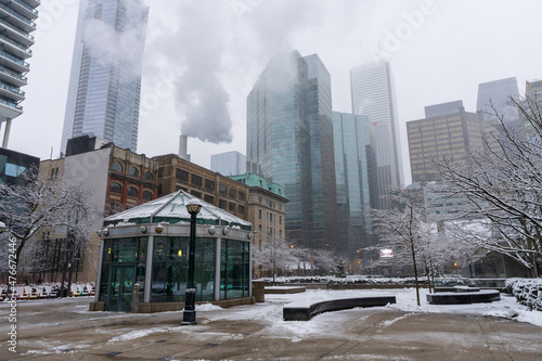 Toronto, Ontario, Canada - December 18 2021 : David Pecaut Square in a snowy winter day. Toronto skyscrapers skyline in the background. photo