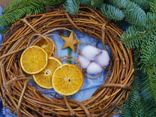 Photo of a set of materials for making a stylish Christmas wreath - vine wreath form  dried orange slices  cotton flower  fir tree branches  wooden star.