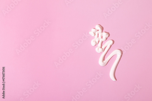 Drops of cosmetic or healing cream on pink surface with copy space