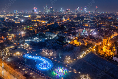 Warszawa, multimedialny park fontann ozdobiony świątecznymi dekoracjami i oświetleniem, widok z lotu ptaka na odległe centrum miasta zimą #476673896
