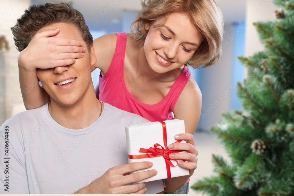 laughing man embracing happy wife with christmas presents in living room, laughing man embracing happy wife with christmas presents in living room,
