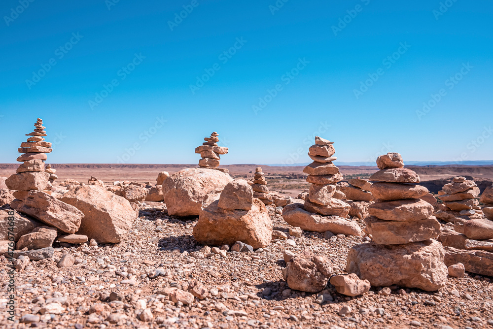 Stack of rocks on deserted mountain landscape against clear blue sky