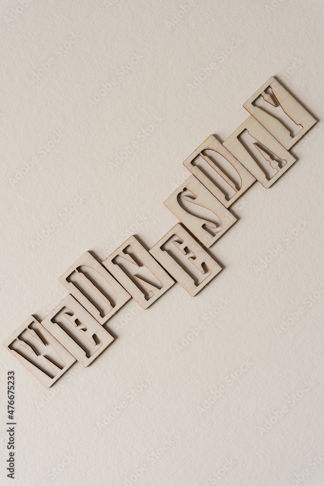 the word "wednesday" (day of the week) in wooden stencil font on textured ivory paper - obrazy, fototapety, plakaty 