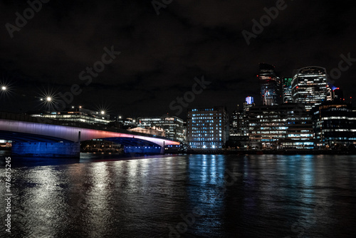 Panoramic view of the London financial district with many skyscrapers in the center of London at night. 
