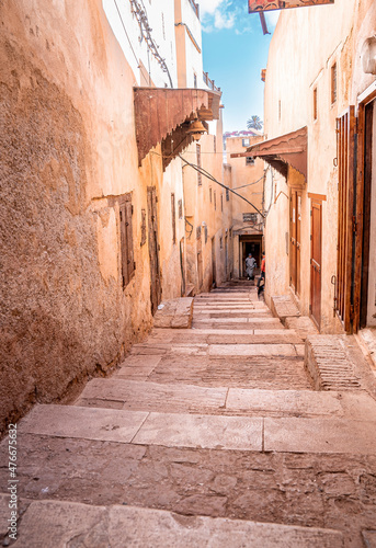 Fototapeta Naklejka Na Ścianę i Meble -  Narrow old alley of stone flooring staircase with residential structure on both side