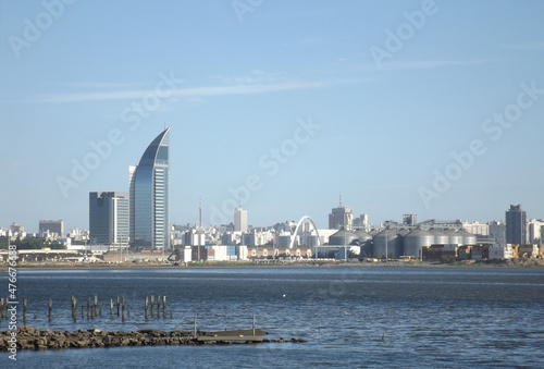Uruguay port skyline. Buildings of the port area on the coast of the bay of Montevideo. Antel Tower, Palacio Salvo, cranes, customs, containers and ships in the water at sunset. photo