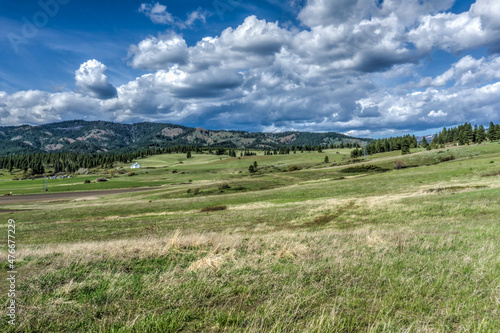 farmland with hills, clouds and blue sky