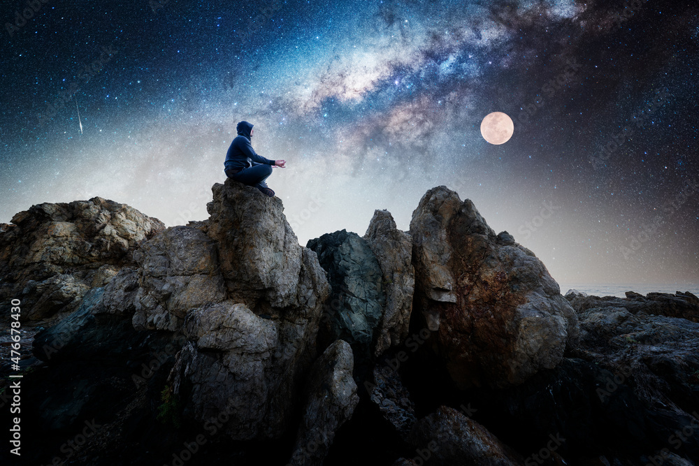 Silhouette of a person meditating on the top one the mountain in lotus ...