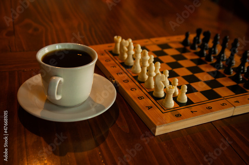 Taza con café y ajedrez de madera