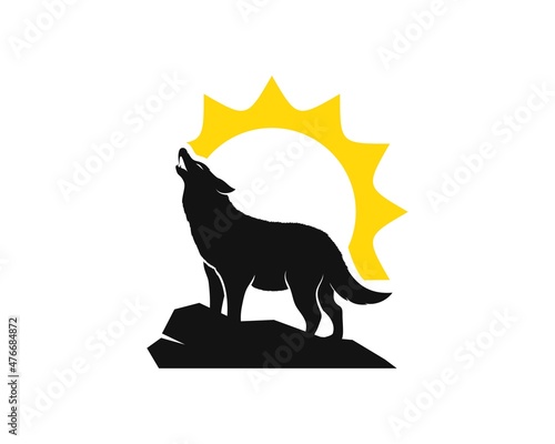 Howling wolf in the peak mountain and sun behind