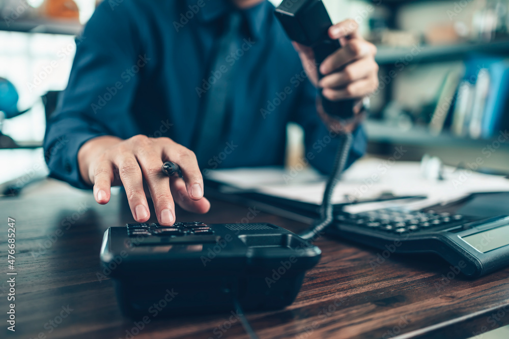 Fototapeta premium businessman dialing desk phone in the office. Telephone dialing ,contact and customer service.