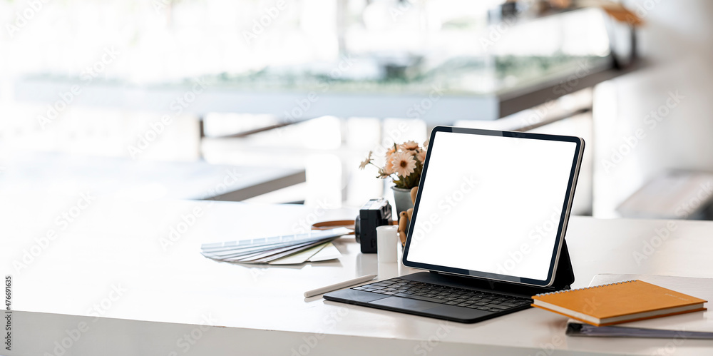 Mockup blank screen portable tablet with magic keyboard on white table in modern office room. Mockup blank screen portable tablet with magic keyboard on white table in modern office room.