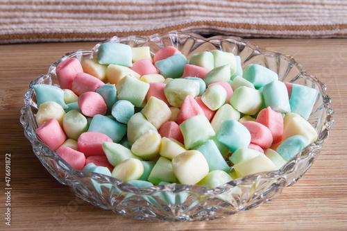 Colorful pillow mints made from scratch at home; Homemade butter mints in pastel colors in a glass serving dish