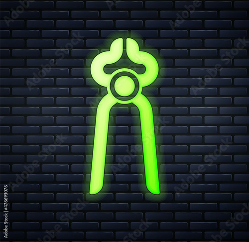 Glowing neon Blacksmith pliers tool icon isolated on brick wall background. Vector