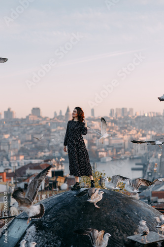 Canvas Print Happy woman on the roof with a view of Istanbul and seagulls in the sky, Turkey