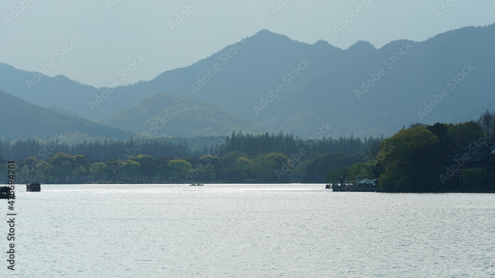 The beautiful lake landscapes in the Hangzhou city of the China in spring with the peaceful lake and fresh green mountains