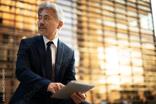 Senior businessman with digital tablet. Man holding credit card. Handsome man in suit using tablet.