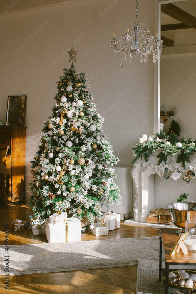 Christmas interior in retro style. White fireplace and mirror with christmas tree garland.