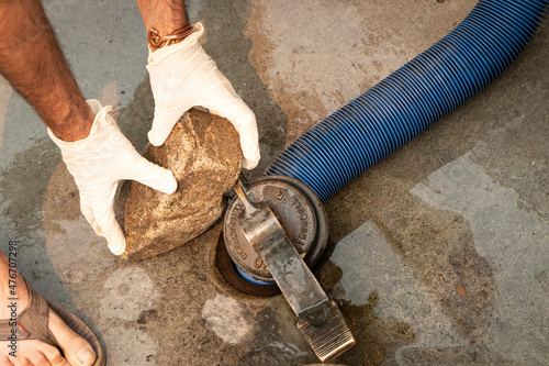 Foto Placing weight on sewer hose at RV dump station hole, to dump wastewater and sew