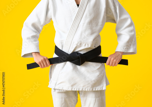 Female karate instructor on color background