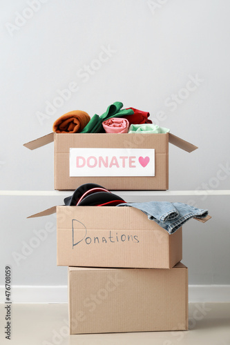 Obraz na płótnie Cardboard boxes with donation clothes on light background